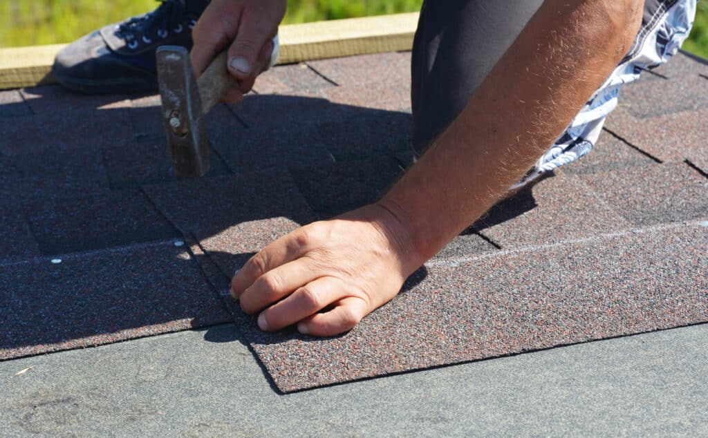 Close-up of shingles being replaced by a roofer