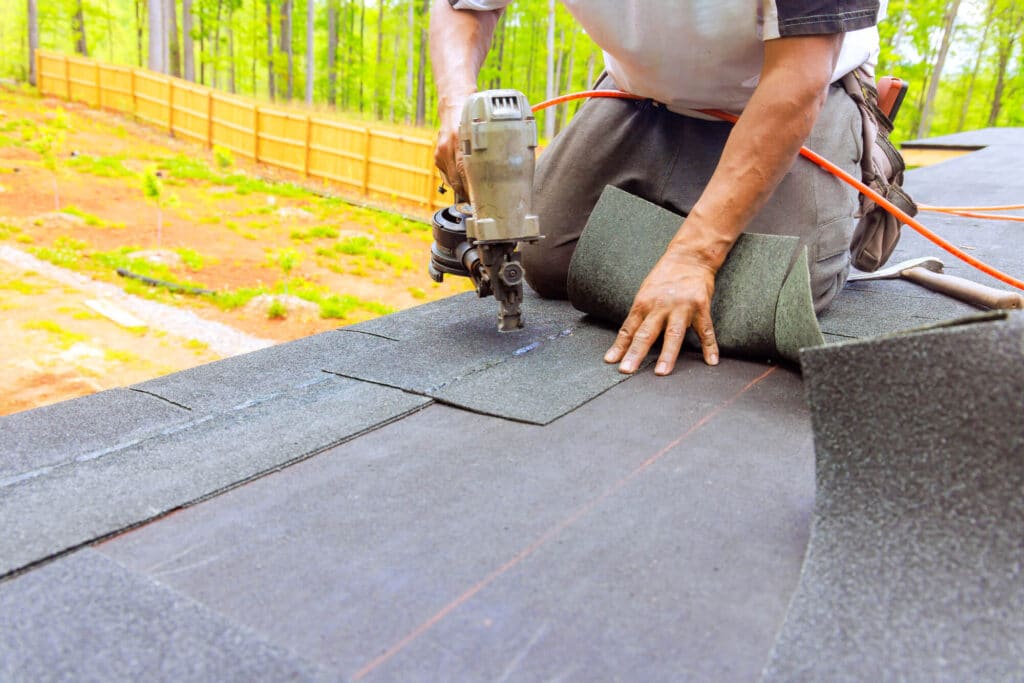 Commercial roofer installing a shingle